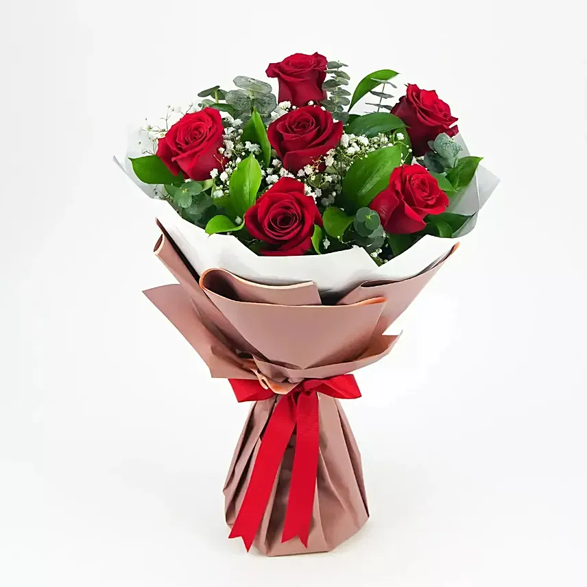 باقة ورد أحمر بغلاف جميل وشريطة حمراء: زهور عيد الحب إلى أم القيوين