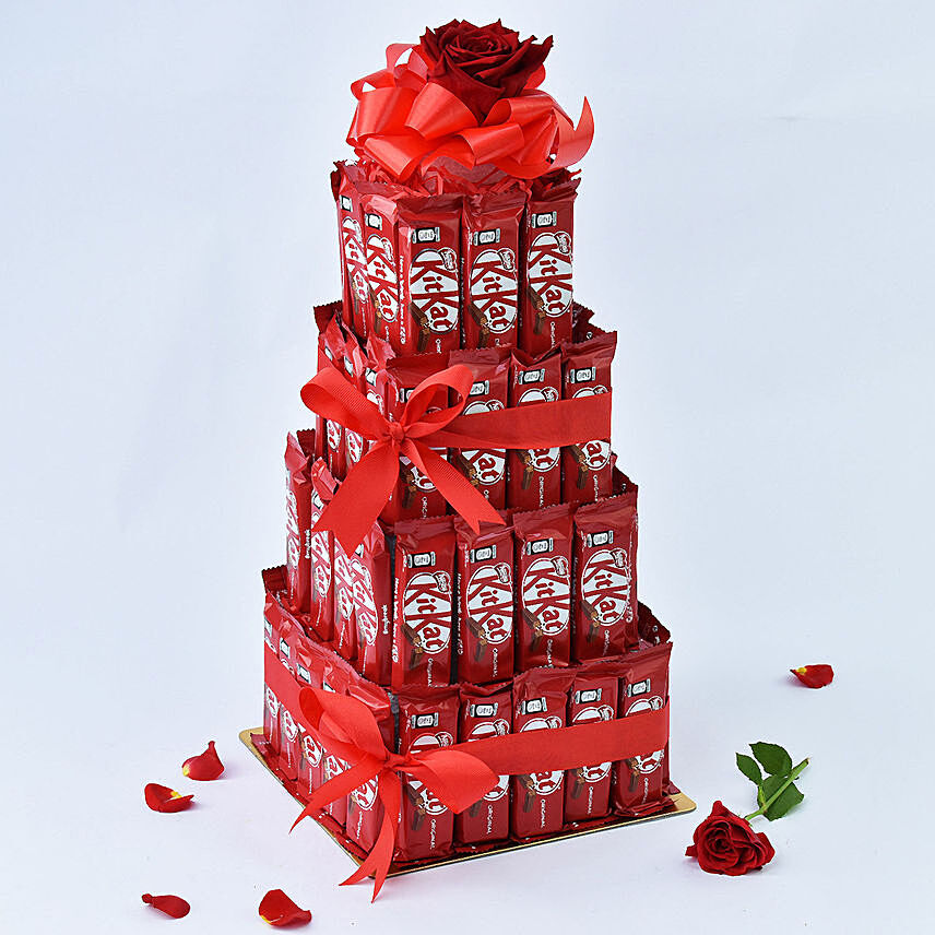 برج من شوكولاتة كيت كات الشهية مع وردة حمراء وشرائط حمراء