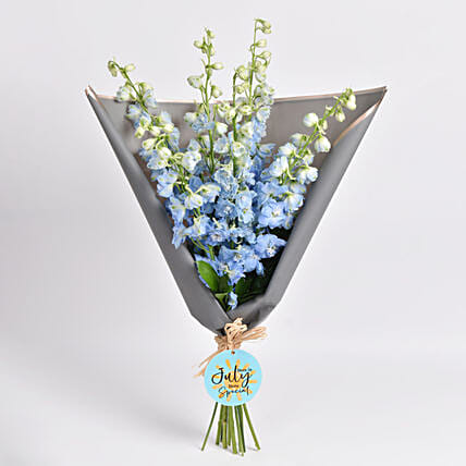 باقة ورد ديلفينيوم أزرق في غلاف رمادي وبطاقة: توصيل في ساعة