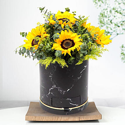 باقة من ورود عباد الشمس في وعاء أسود مع شوكولا فيرير روشيه: باقة ورد عيد رأس السنة