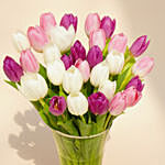 باقة 50 وردة توليب أرجوانية وبيضاء ووردية في مزهرية جميلة