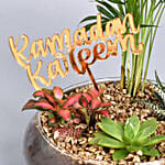 تنسيقة نباتات خضراء مع علامة عيد مبارك ذهبية