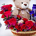 سلة جميلة تحتوي على دمية دب وورد أحمر وأبيض وشوكولاتة كادبور