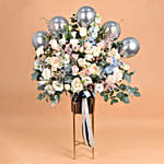 باقة ورد أبيض وردي مع بالونات فضية في فازة مميزة