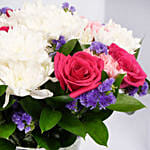 باقة ورود وردية وبيضاء مرتبة في مزهرية زجاجية